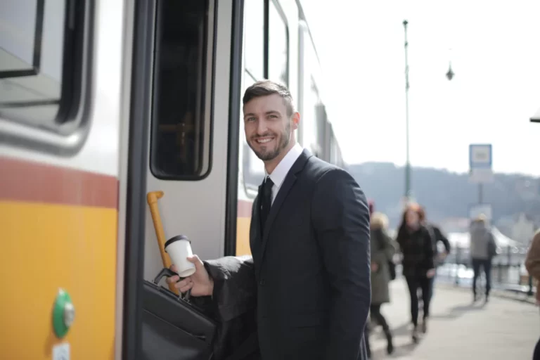 Ein Mann mit Anzug steigt in einen Zug ein